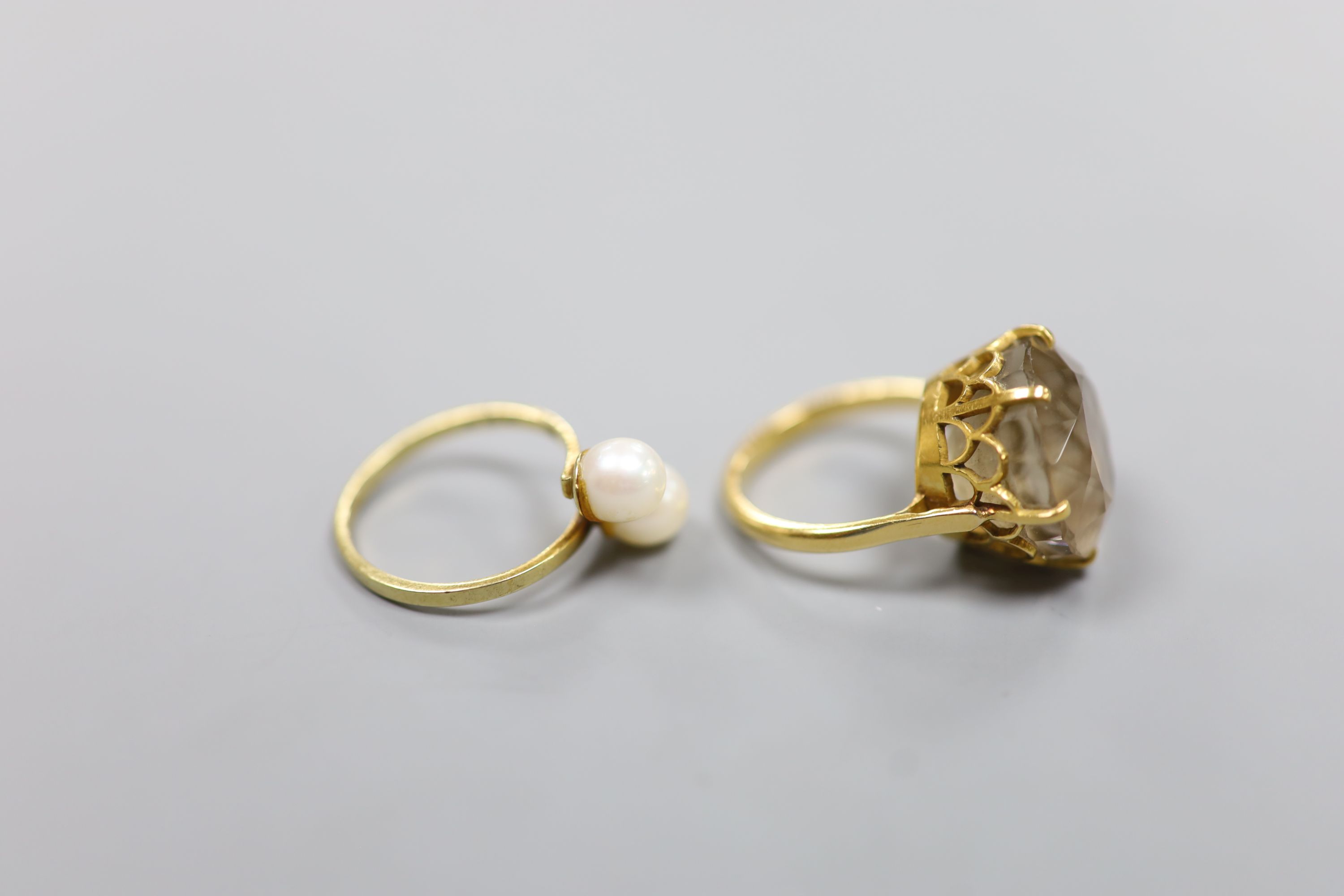 A yellow metal and smoky quartz dress ring, gross 8.2 grams and a 585 and two stone cultured pearl set crossover ring, gross 2.3 grams.